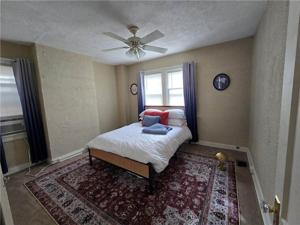 6501 Deary Street Pittsburgh, PA 15206 - Photo 17 of 47 a bedroom with a bed rug and wooden floor