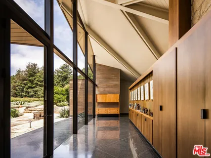 a living room with a floor to ceiling window and wooden floor