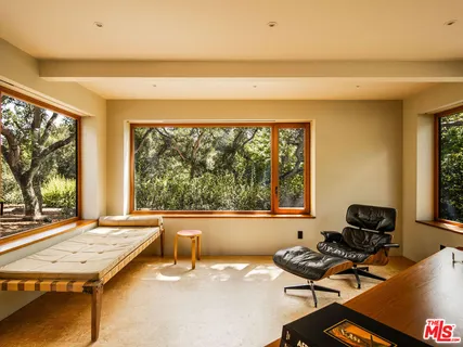 a view of swimming pool with lawn chairs and plants