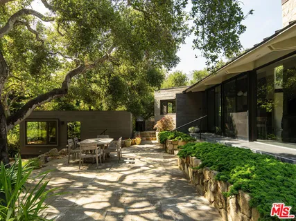 a view of a patio with table and chairs and potted plants with wooden floor and fence