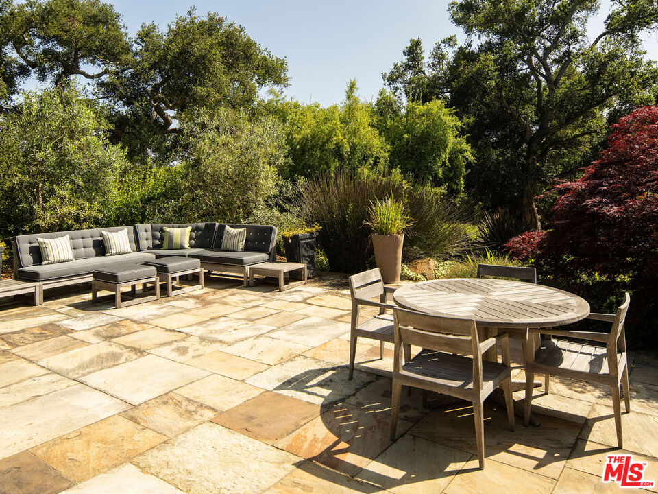 650 San Ysidro Road Santa Barbara, CA 93108 - Photo 37 of 55 a view of a patio with table and chairs and potted plants with wooden floor and fence