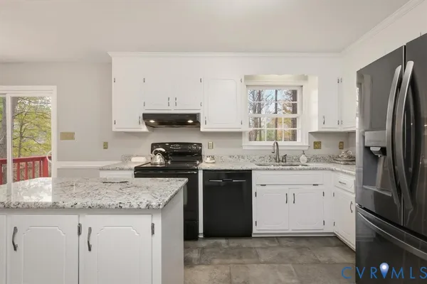 a kitchen with granite countertop stainless steel appliances a sink stove and refrigerator