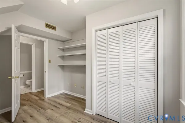 a view of an empty room with cabinet and a window