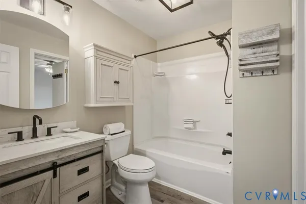 a bathroom with a granite countertop sink a toilet and shower