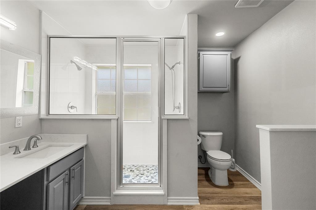 2917 Harlow Road Commerce, TX 75428 - Photo 14 of 40 a bathroom with a toilet sink and a mirror