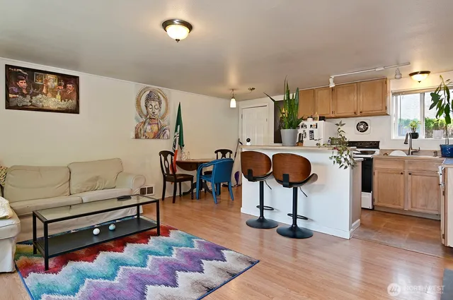 a living room with furniture a wooden floor and next to a window