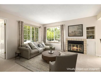 a living room with furniture a large window and a fireplace