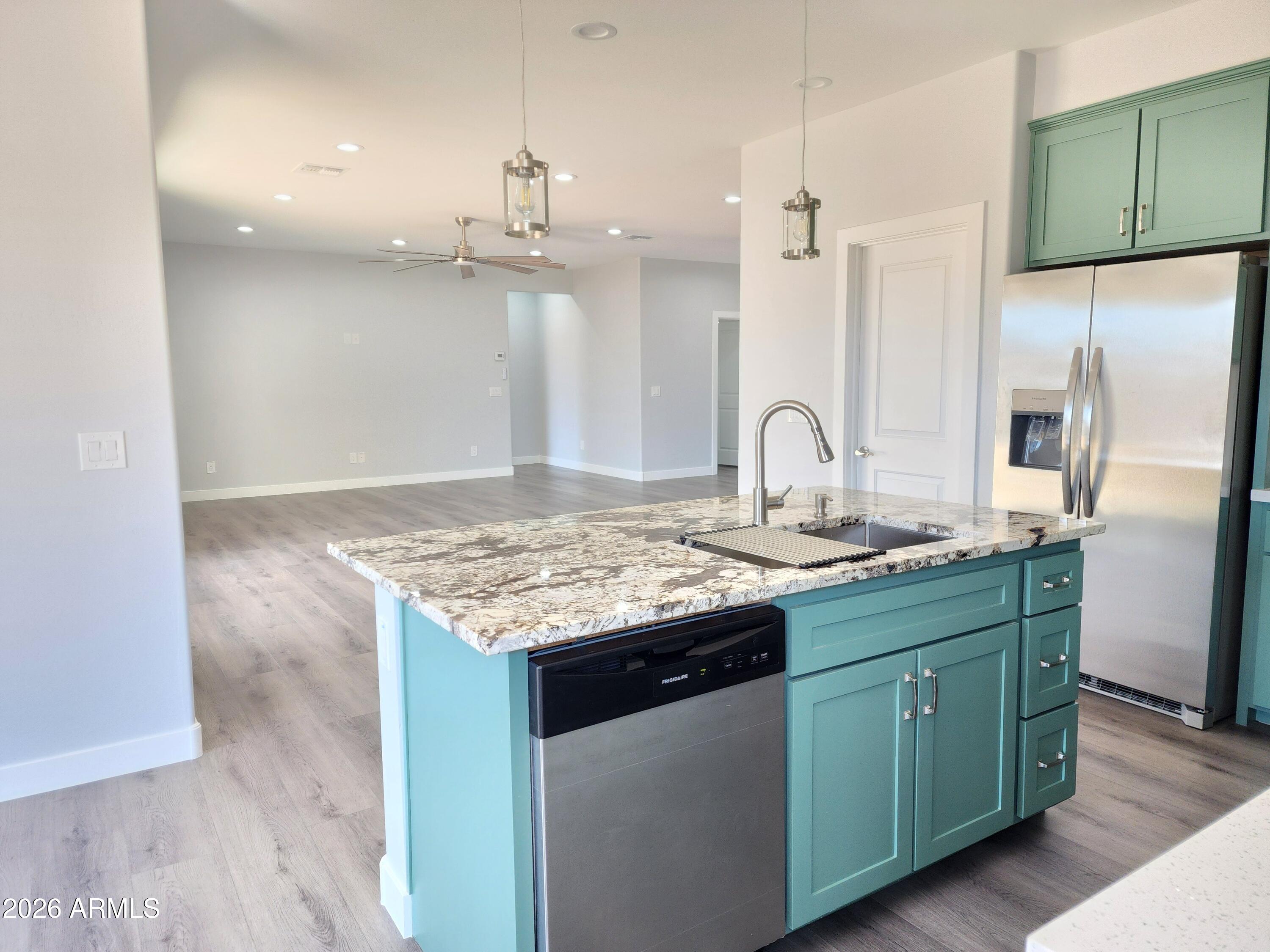13564 South Durango Road Arizona City, AZ 85123 - Photo 25 of 30 a kitchen with granite countertop a sink cabinets and stainless steel appliances