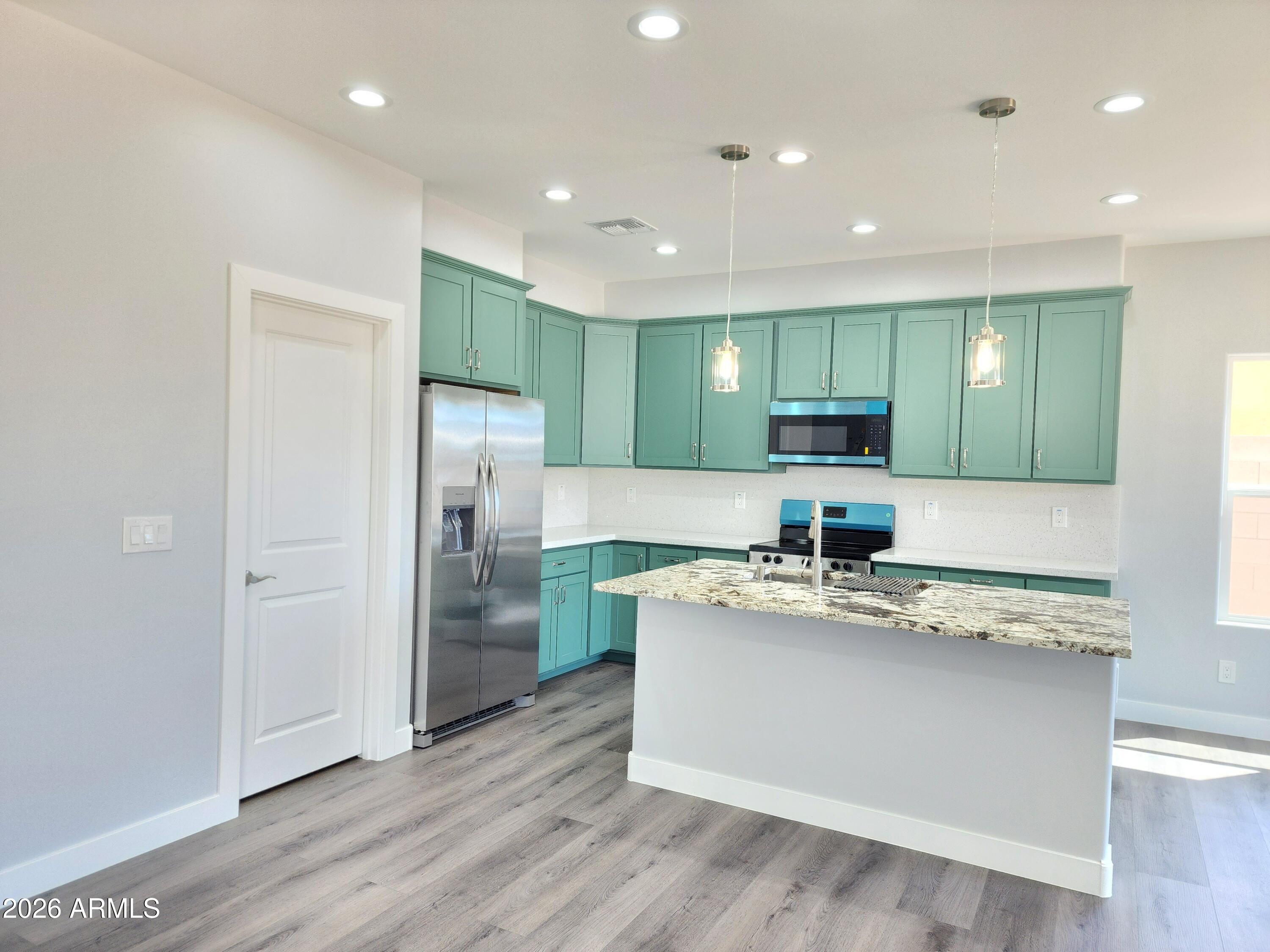 13564 South Durango Road Arizona City, AZ 85123 - Photo 27 of 30 a large kitchen with stainless steel appliances granite countertop a sink and a refrigerator