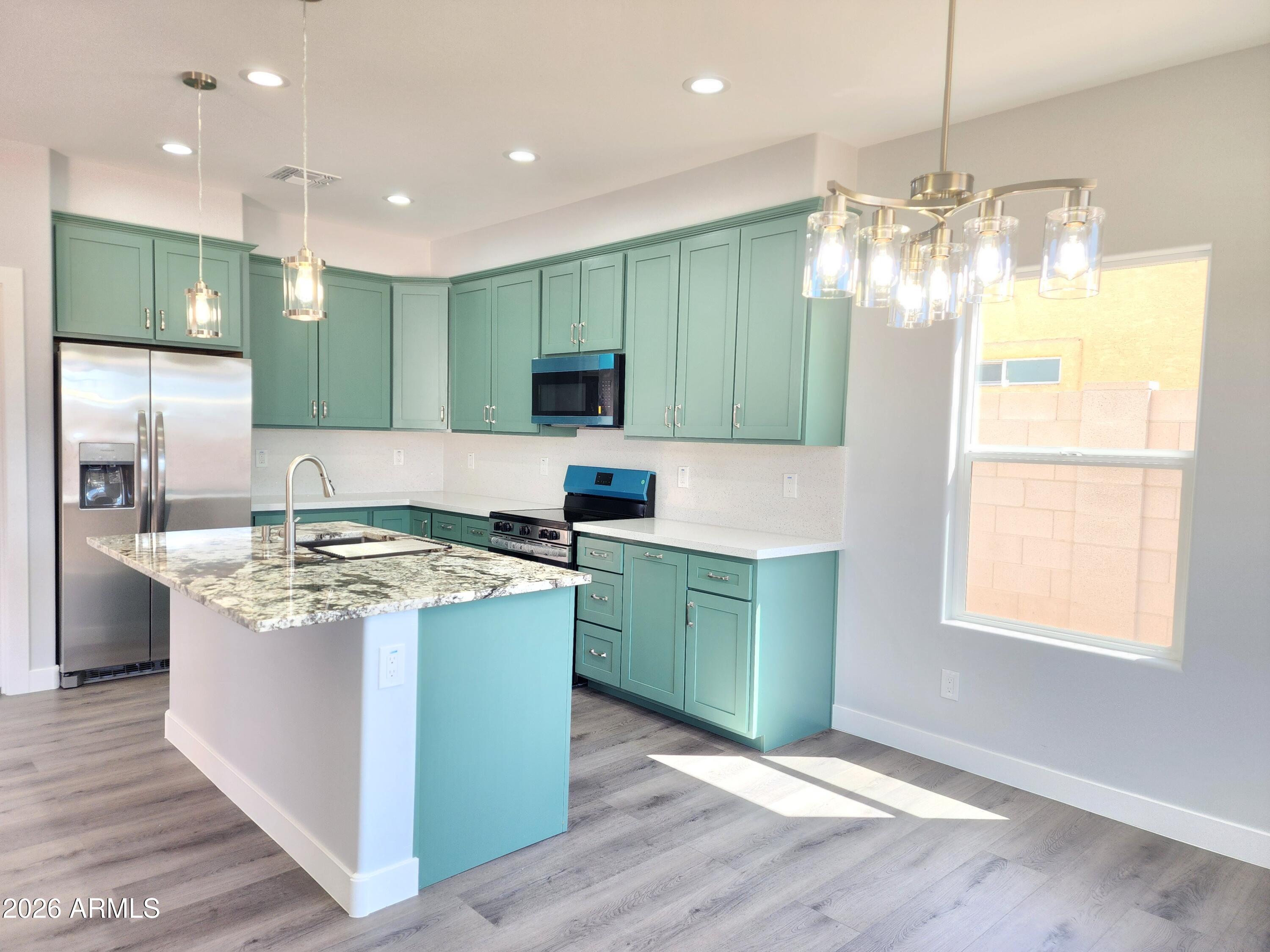 13564 South Durango Road Arizona City, AZ 85123 - Photo 28 of 30 a kitchen with kitchen island granite countertop a sink and a refrigerator