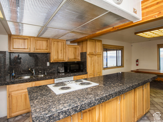 588 Raspberry Patch Road Garden City, UT 84028 - Photo 15 of 74 Kitchen with ventilation hood, brick floors, white appliances, decorative backsplash, and a center island