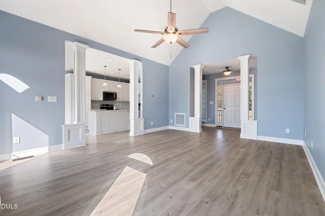 a view of empty room with wooden floor and fireplace