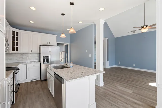 a kitchen with stainless steel appliances granite countertop a sink stove and refrigerator