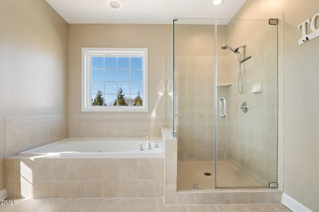a spacious bathroom with a bathtub sink and mirror