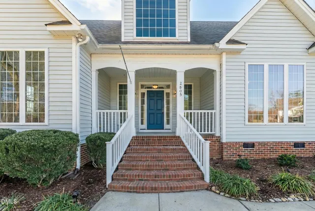 a view of a house with a big yard and palm trees