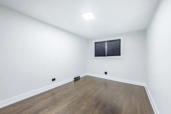 a room with wooden floor and white walls