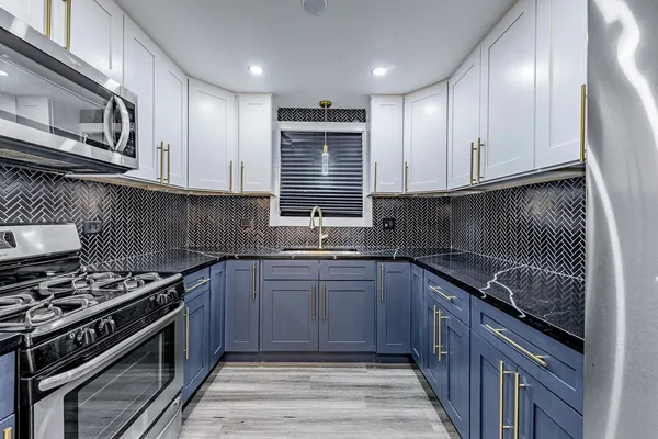 a kitchen with stainless steel appliances granite countertop a sink stove and cabinets