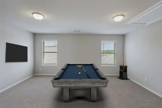 a room with pool table and windows