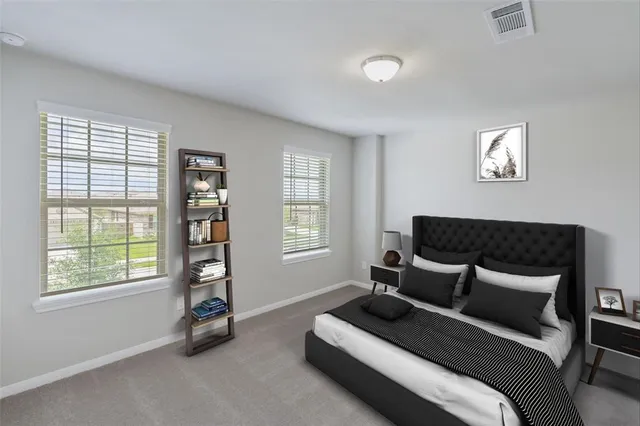 a spacious bedroom with a bed a couch and a window