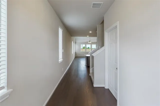 a view of a hallway with wooden floor