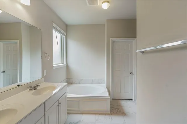 a bathroom with a tub sink and mirror