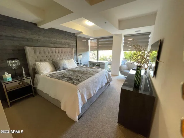 a bed room with a bed window and a television