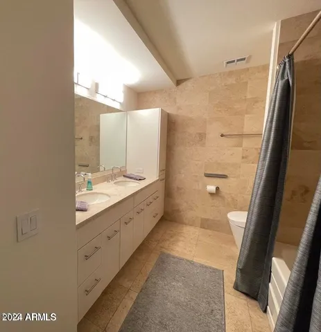 a bathroom with a granite countertop sink mirror and a shower