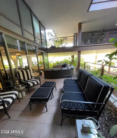 a living room with balcony furniture and a floor to ceiling window