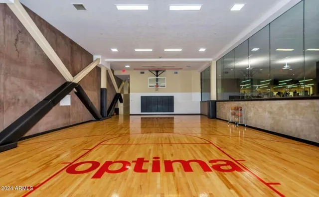 a room with gym equipment and wooden floor