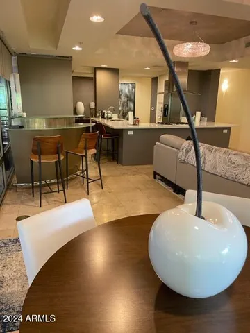 a living room with couches and kitchen view with wooden floor