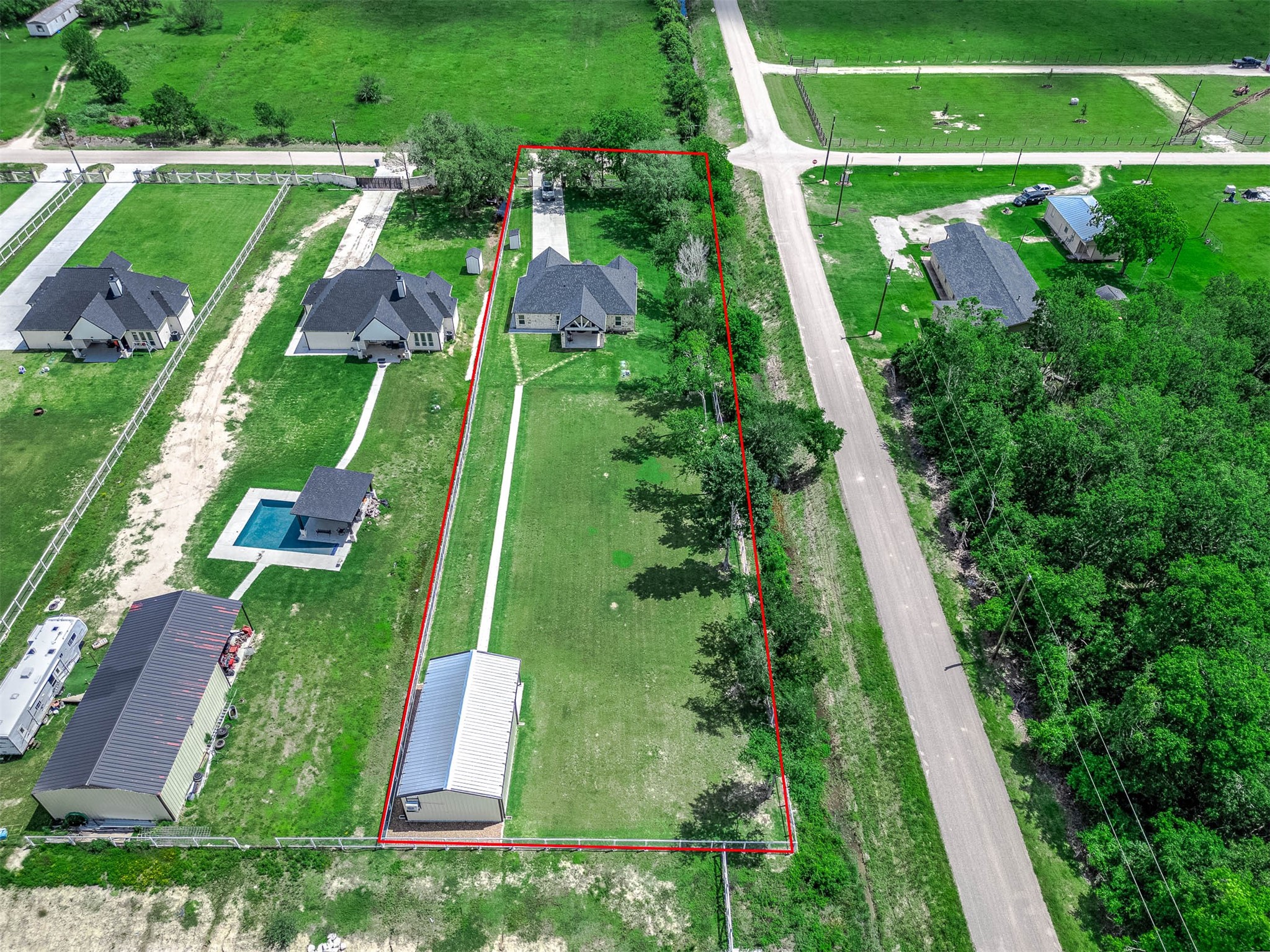 8032 Short Road Needville, TX 77461 - Photo 43 of 50 Outlined in red, this aerial view provides a clear look at the property boundaries, showcasing the home, additional building, and expansive usable land. The surrounding open space and neighboring acreage properties enhance the peaceful rural setting and overall sense of privacy.