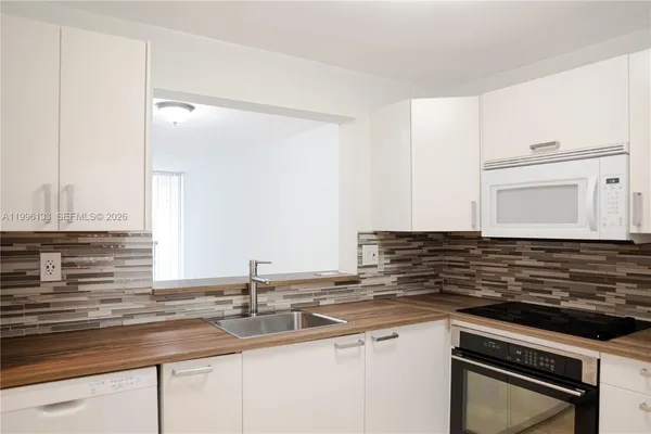 a kitchen with granite countertop a sink and a stove