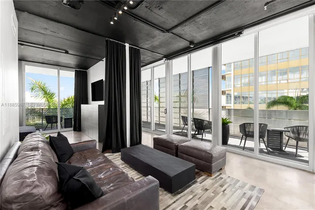 a living room with furniture and a floor to ceiling window