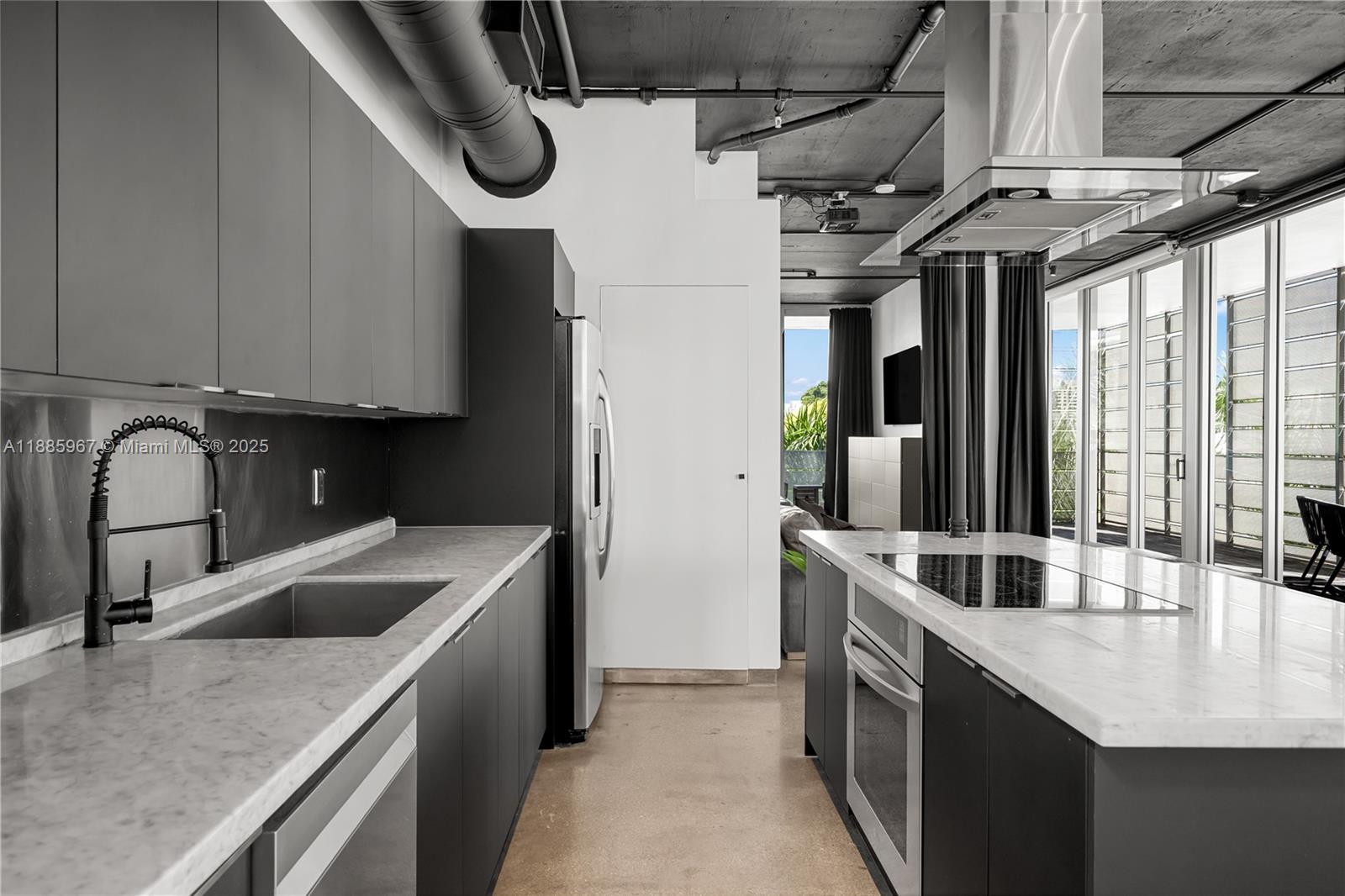 1700 Meridian Avenue, Unit 501 Miami Beach, FL 33139 - Photo 24 of 57 a kitchen with stainless steel appliances granite countertop a sink a counter space and cabinets