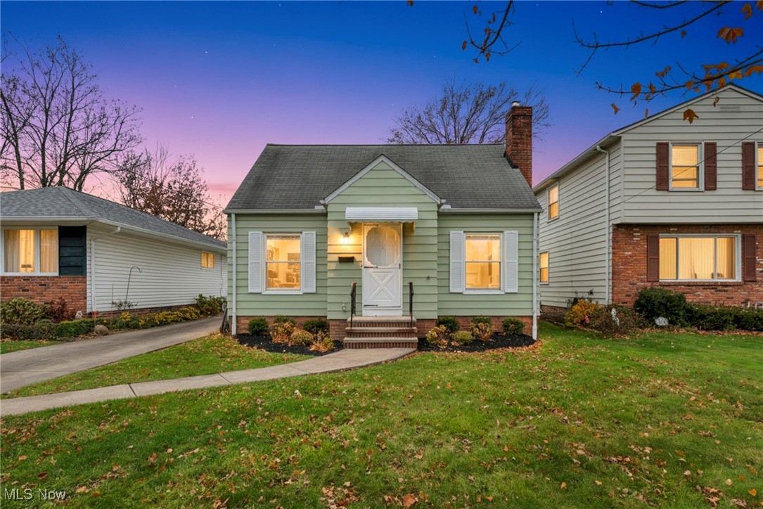 View of front of house with a front lawn, street view at night
