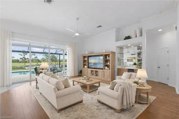 a living room with furniture large windows and a flat screen tv