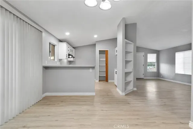 a view of a kitchen with wooden floor and a window