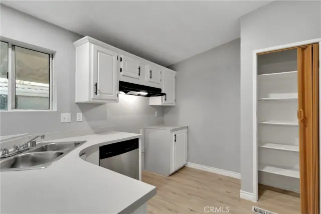 a kitchen with stainless steel appliances a sink a stove and white cabinets