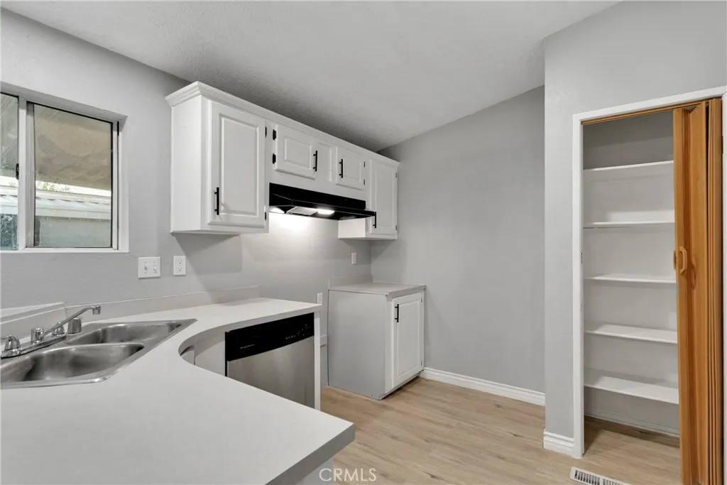 8450 G, Unit 63 Hesperia, CA 92345 - Photo 14 of 31 a kitchen with stainless steel appliances a sink a stove and white cabinets