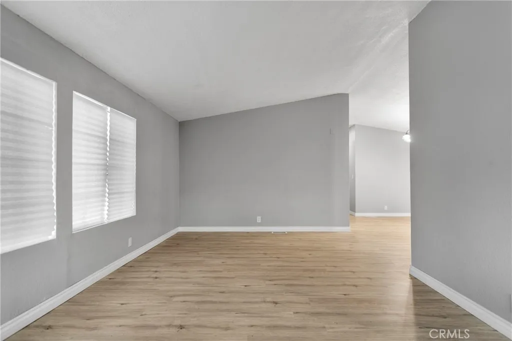 8450 G, Unit 63 Hesperia, CA 92345 - Photo 10 of 31 a view of an empty room with wooden floor and a window
