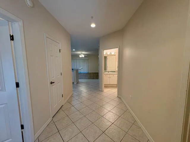 a view of a hallway with wooden floor and a bathroom