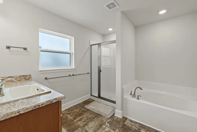 a en suite bathroom with a granite countertop sink a large mirror and a