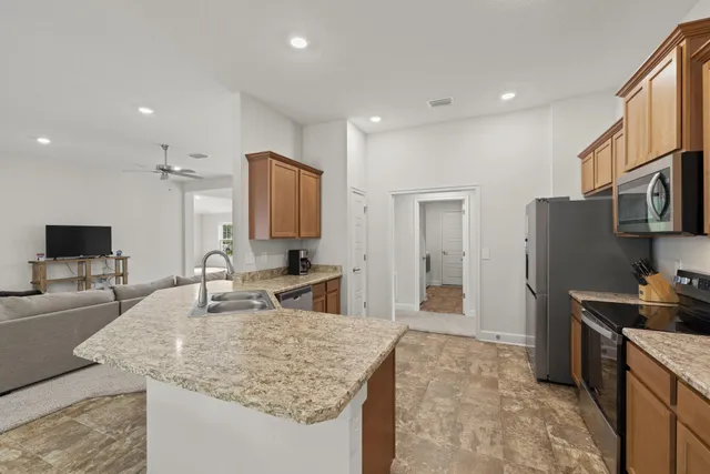a kitchen with granite countertop a sink stainless steel appliances and cabinets