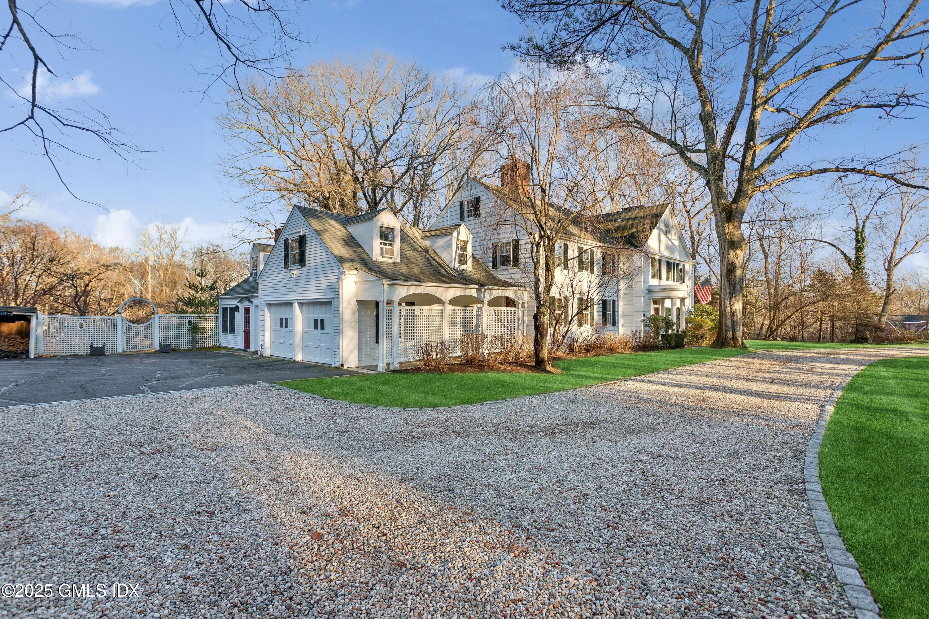 2 Laurel Road Stamford, CT 06903 - Photo 2 of 24 a view of a white house next to a yard with big trees
