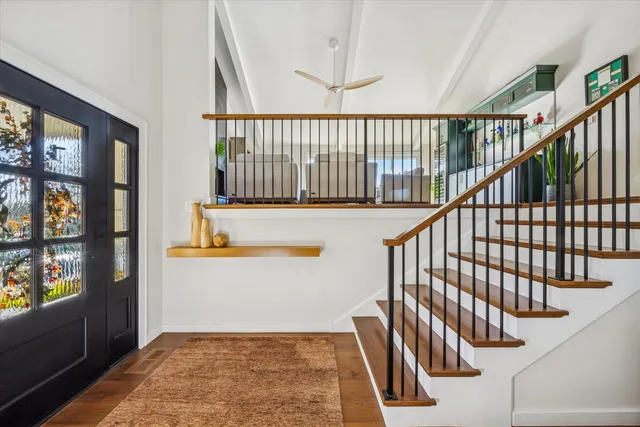 a view of staircase with lots of frames on wall and a window