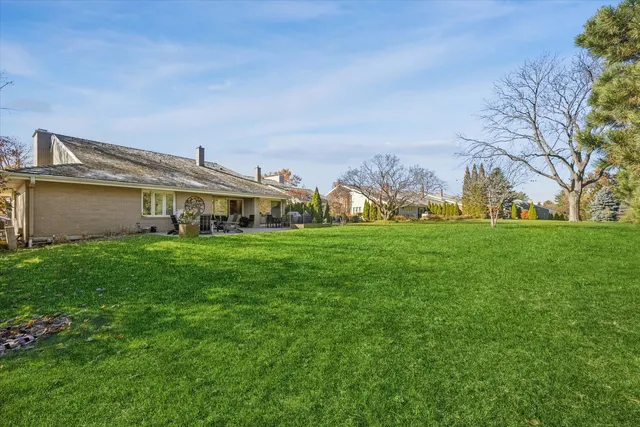 a view of a house with a big yard and large trees
