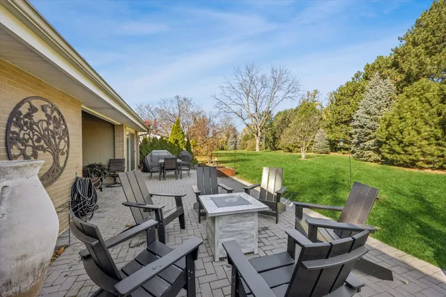 a view of a patio with table and chairs and potted plants with wooden floor and fence