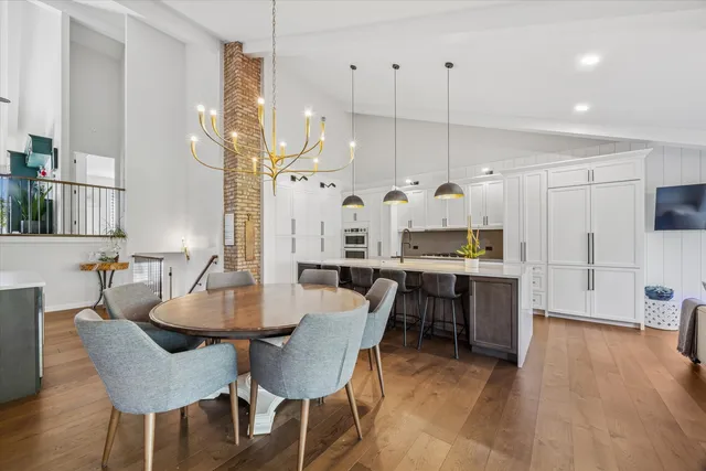 a large kitchen with a table chairs and a wooden floor