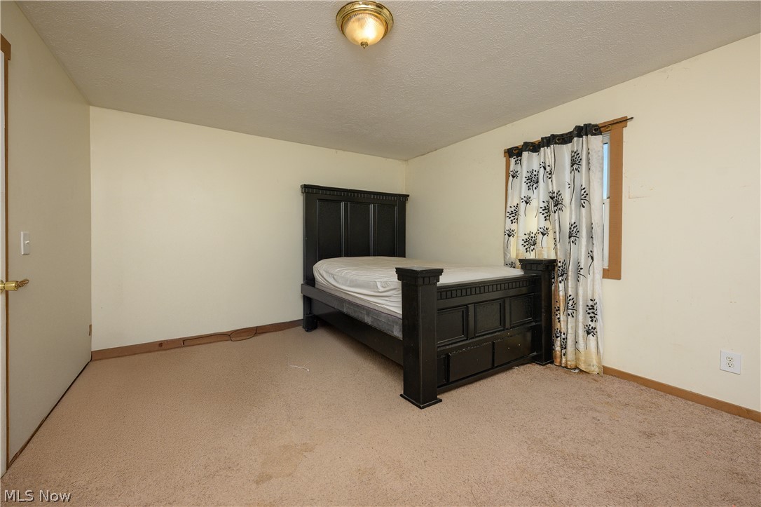 8200 Cutler Road Southwest Sherrodsville, OH 44675 - Photo 18 of 26 Bedroom featuring a textured ceiling and light carpet