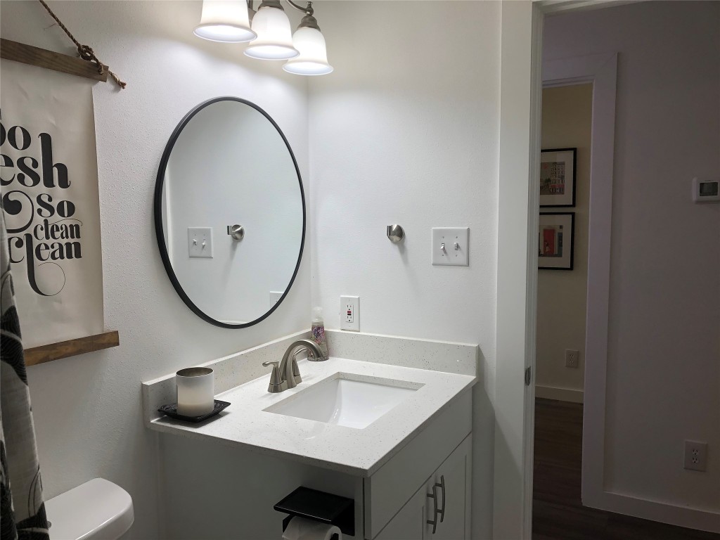 6409 Burns Street, Unit 306 Austin, TX 78752 - Photo 11 of 24 a bathroom with a toilet sink and mirror
